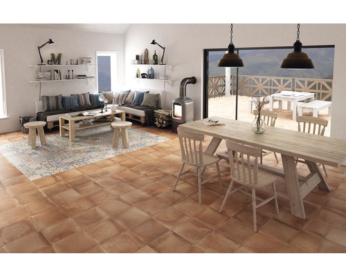 Lichte woonkamer met zithoek, eettafel en houtkachel op tegelvloer.