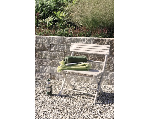 Tuin scène met klapstoel, dekens, drinkfles en stenen muur