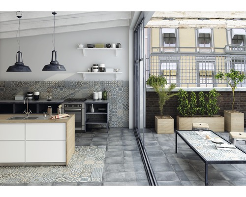 Lichte keuken met kookeiland, tegelvloer, keukentafel en planten op het terras