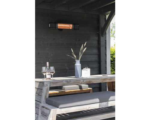 Terrasscène met terrasverwarmer, houten tafel, banken, decoratie en drankjes