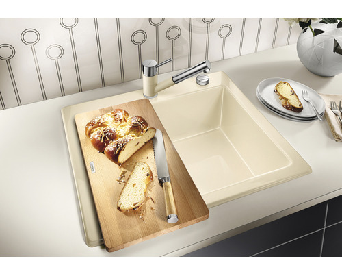 Spoelbak met snijplank en kraan op een aanrecht.