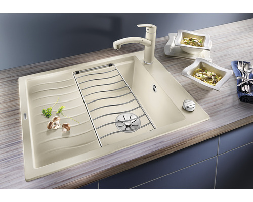 Spoelbak met afdruiprek, afdruiprooster en keukenkraan op een aanrecht met twee schalen pasta