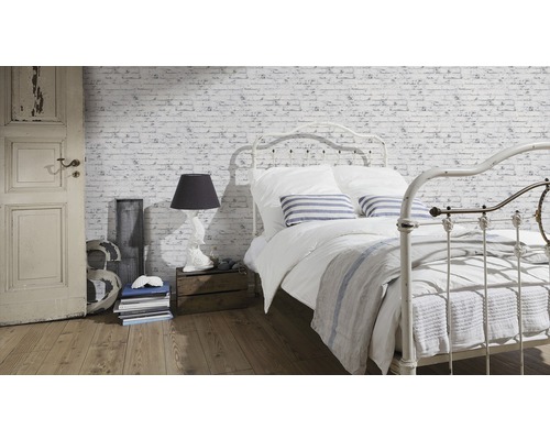 Lichte slaapkamer met bed voor bakstenen muurbehang