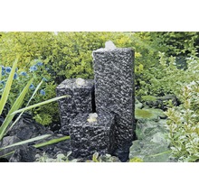 Tuinfontein van graniet met drie zuilen in de tuin