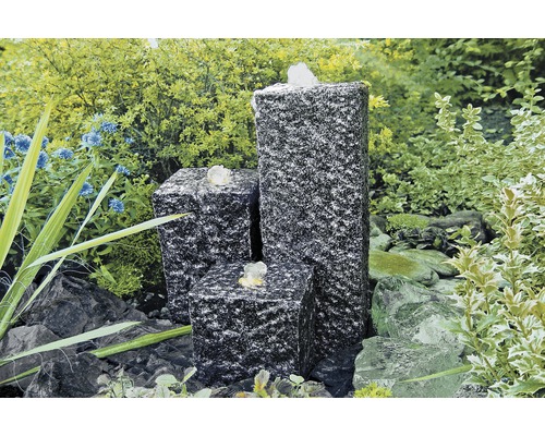 Tuinfontein van graniet met drie zuilen in de tuin