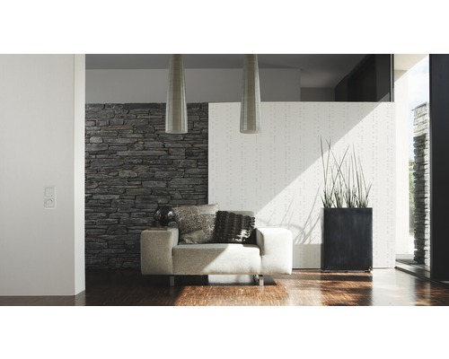 Moderne woonkamer met fauteuil, stenen muur en kamerplant