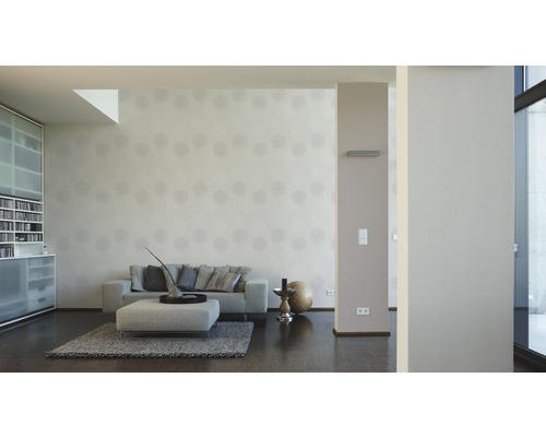 Woonkamer met bank, ottomane, vloerkleed en behang met motief