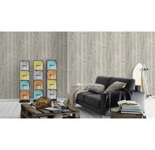 Woonkamer met grijs behang in houtlook, zwarte bank en kleurrijke metalen kasten ter decoratie.