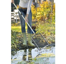 Een persoon gebruikt een vijvernet om een tuinvijver schoon te maken.