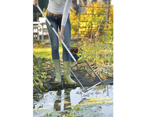 Een persoon gebruikt een vijvernet om een tuinvijver schoon te maken.