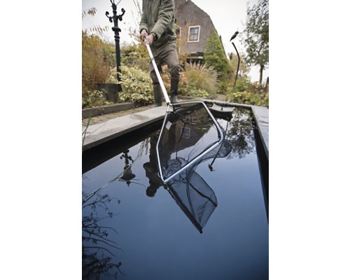 Man hanteert een vijvernet in de tuinvijver