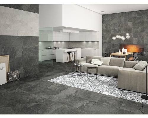 Woonkamer met vloer- en wandtegels in steenlook, bank en open keuken
