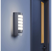 Brandende buitenwandlamp met bewegingssensor aan een muur
