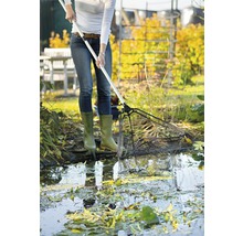 Een persoon maakt een tuinvijver schoon met een vijvernet.