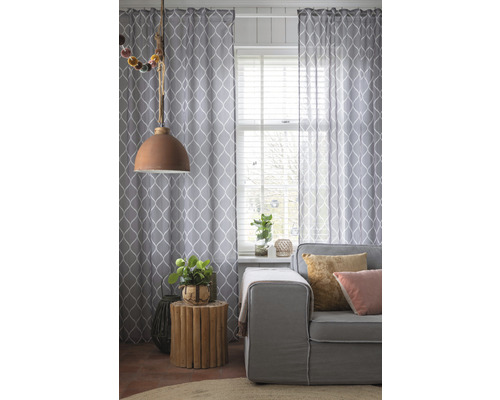 Woonkamer met gordijnen, bank en bijzettafel