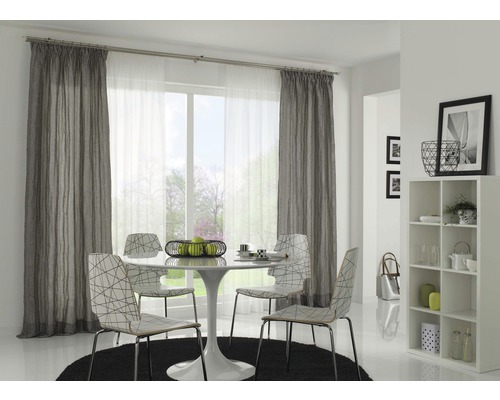 Eetkamer met gordijnen, eettafel en stoelen op een vloerkleed