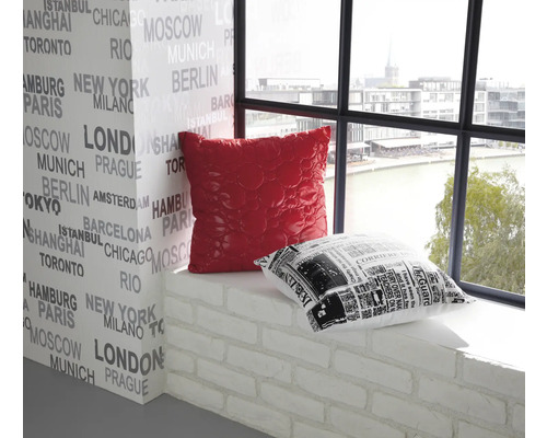 Decoratief interieur met een rood en een zwart-wit kussen op een vensterbank voor een muur bedrukt met stadsnamen