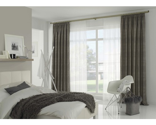 Slaapkamer met bed, stoel, gordijnen en daglicht