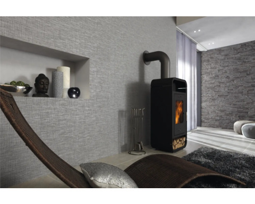 Woonkamer met houtkachel, relaxstoel en decoratieve wandbekleding