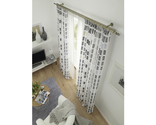 Woonkamer met raamdecoratie inclusief gordijnroede en gordijnen met geometrisch patroon