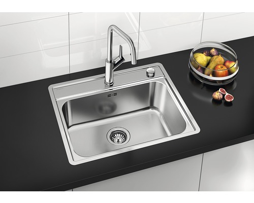 Roestvrijstalen spoelbak met kraan op een werkblad met fruitschaal