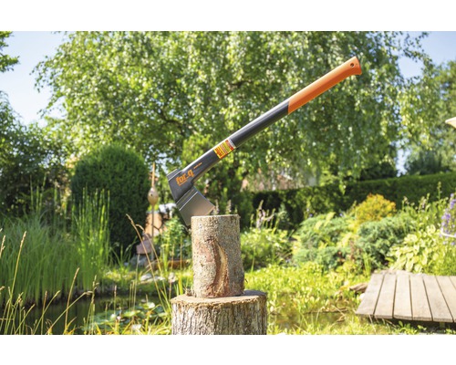 Kloofbijl in boomstam in de tuin