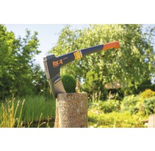 Kloofbijl op een blok hout in de tuin met For_q Logo.