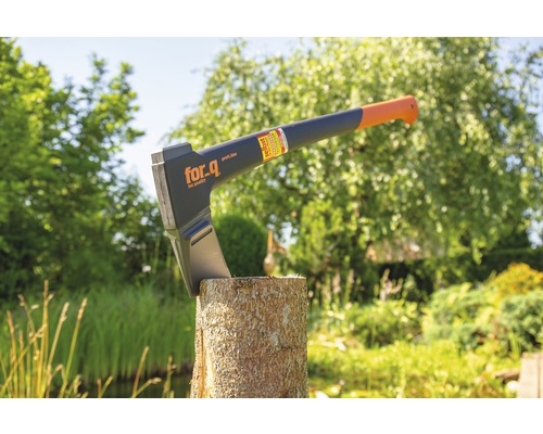 Kloofbijl op een blok hout in de tuin met For_q Logo.