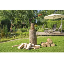 Bijl in houten blok met houtblokken in de tuin.