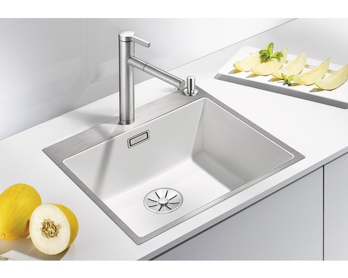 Spoelbak met kraan en zeepdispenser in een lichte keuken