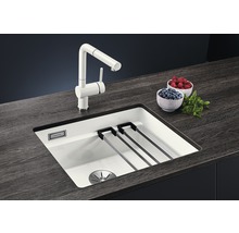 Spoelbak met afdruiprek, kraan en schalen met bessen op een werkblad