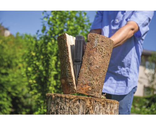 Een persoon hakt hout met een houtklover.