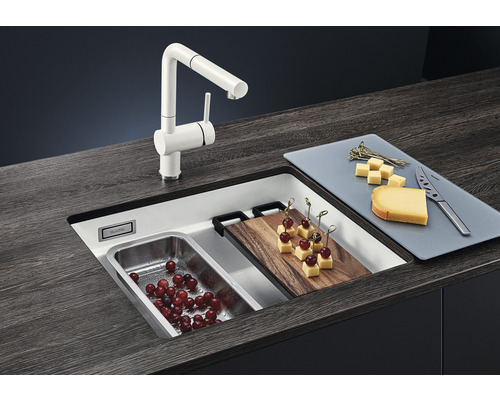 Keuken spoelbak met kraan, snijplank en etenswaren op een werkblad