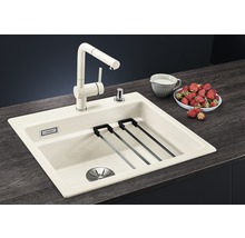 Keukenspoelbak met kraan, afdruiprek en zeepdispenser op een aanrecht met aardbeien en een kan melk