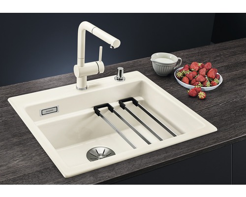 Keukenspoelbak met kraan, afdruiprek en zeepdispenser op een aanrecht met aardbeien en een kan melk