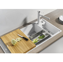 Keuken spoelbak met snijplank, afdruipbak, kraan en gesneden groenten