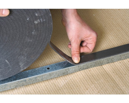 Man bevestigt isolatieband aan metalen profiel