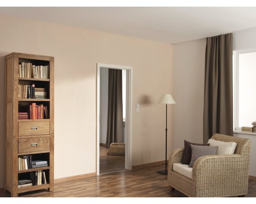 Woonkamer met boekenkast, fauteuil, vloerlamp en deur