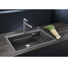 Spoelbak met afdruiprek, kraan en prei op een werkblad