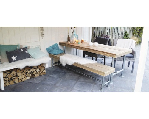 Houten tafel en bank met kussens en decoratie in een tuinomgeving