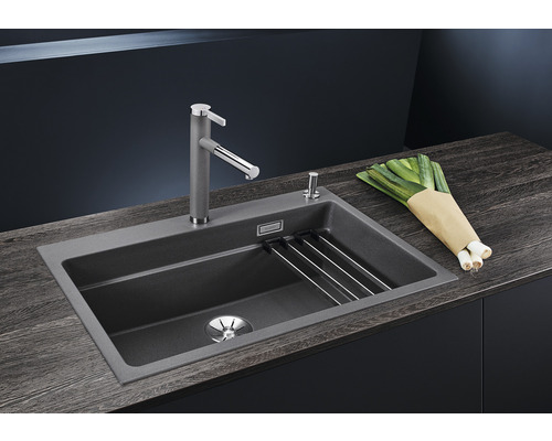 Spoelbak met afdruiprek, kraan, zeepdispenser en lente-uitjes op een donker aanrechtblad