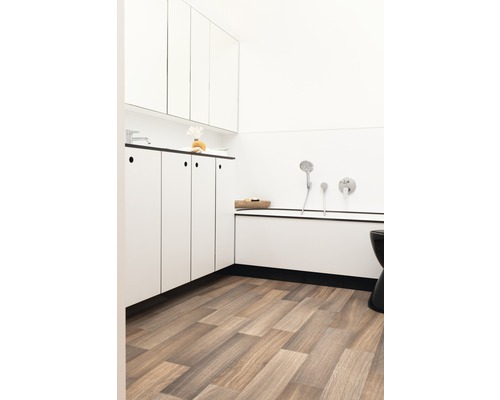 Badkamer met wit meubilair, ligbad en houten vloer