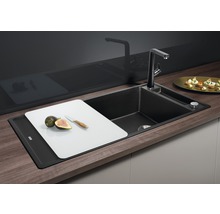 Zwarte gootsteen met kraan, snijplank, vijgen en mes.