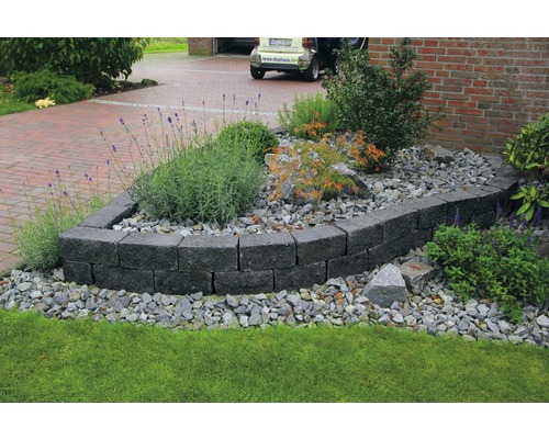 Tuin met natuurstenen muur en grindbed