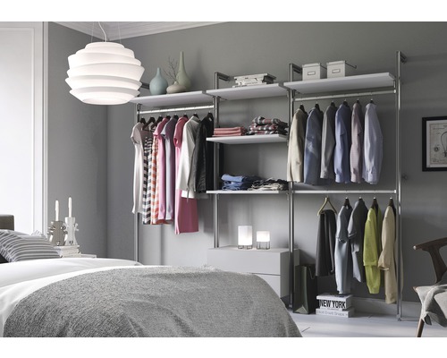 Slaapkamer met inloopkast van metaal en houten vloeren, plus kleding aan hangers