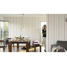 Woonkamer met eettafel, stoelen, bank en gestreept behang voor een lichte en vriendelijke sfeer.