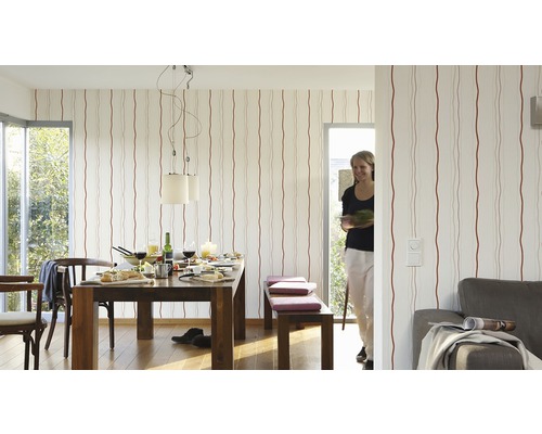 Woonkamer met eettafel, stoelen, bank en gestreept behang voor een lichte en vriendelijke sfeer.