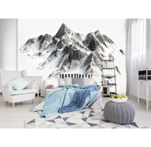 Slaapkamer met behang met bergmotief, bed, fauteuil en tapijt