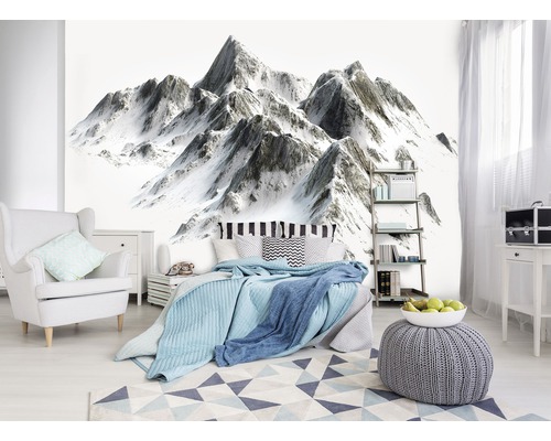 Slaapkamer met behang met bergmotief, bed, fauteuil en tapijt