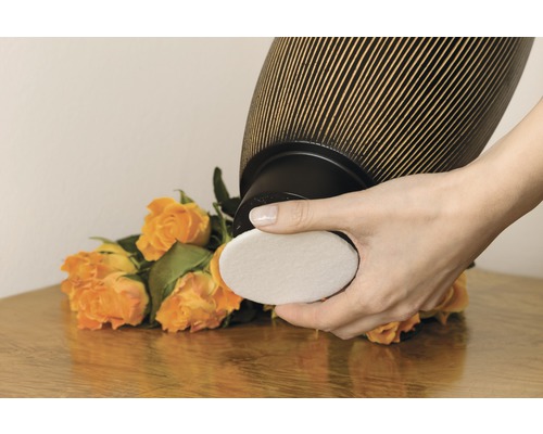 Vrouw vervangt filter van luchtreiniger voor een boeket rozen